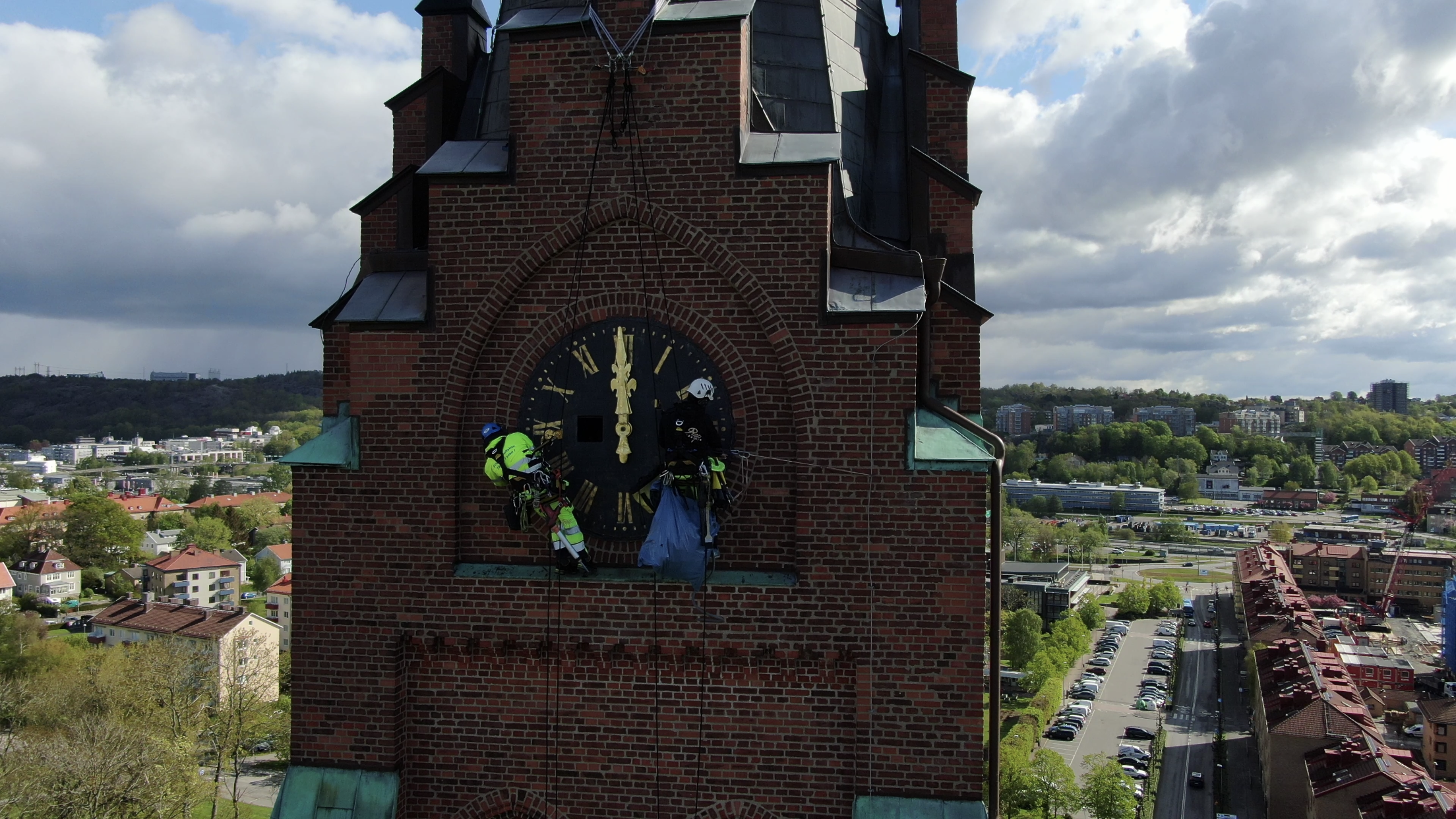 Två fogarbetare som utför höghöjdsarbete med Rope access på kyrktorn